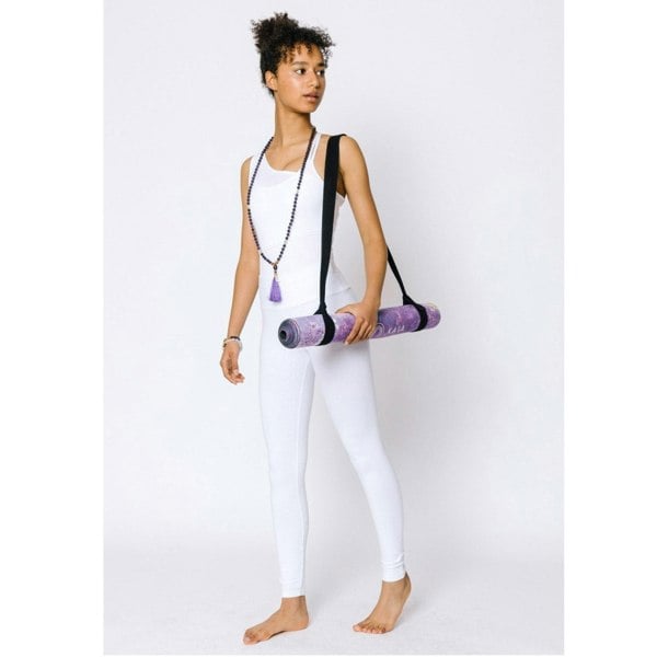 Woman wearing Kati Kaia amethyst mala necklace carrying a purple yoga mat in white activewear