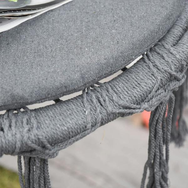 Grey cushion on macrame hanging chair with braided trim and dangling rope fringe