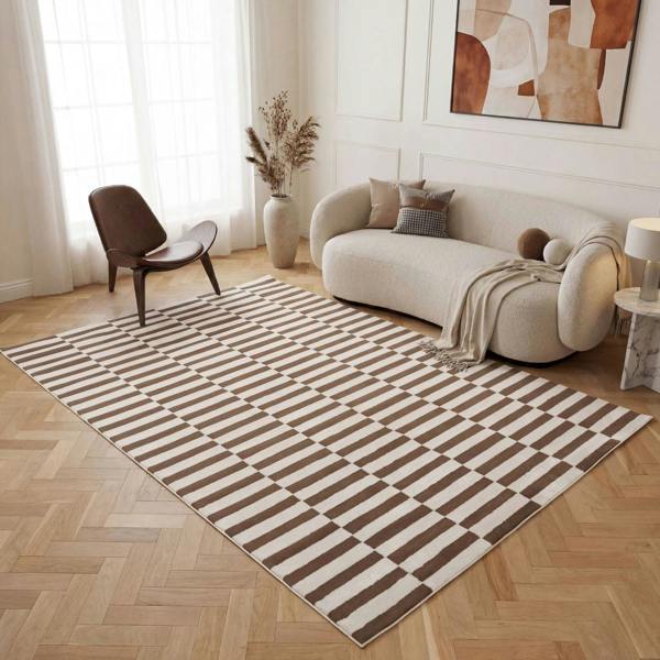 Living room with a striped rug, beige sofa, and abstract art on the wall.