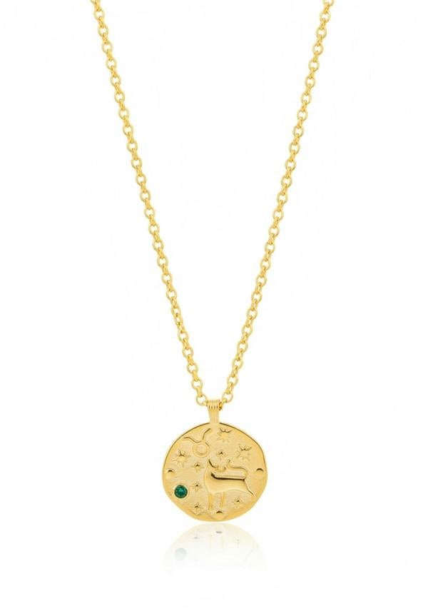 Gold necklace with a round pendant featuring an engraved design and a green gemstone on a white background.