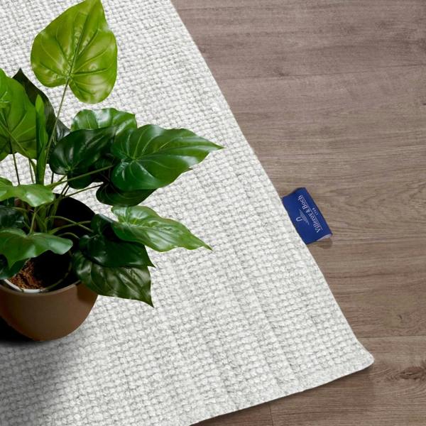 Yoga mat with a plant on a wooden floor