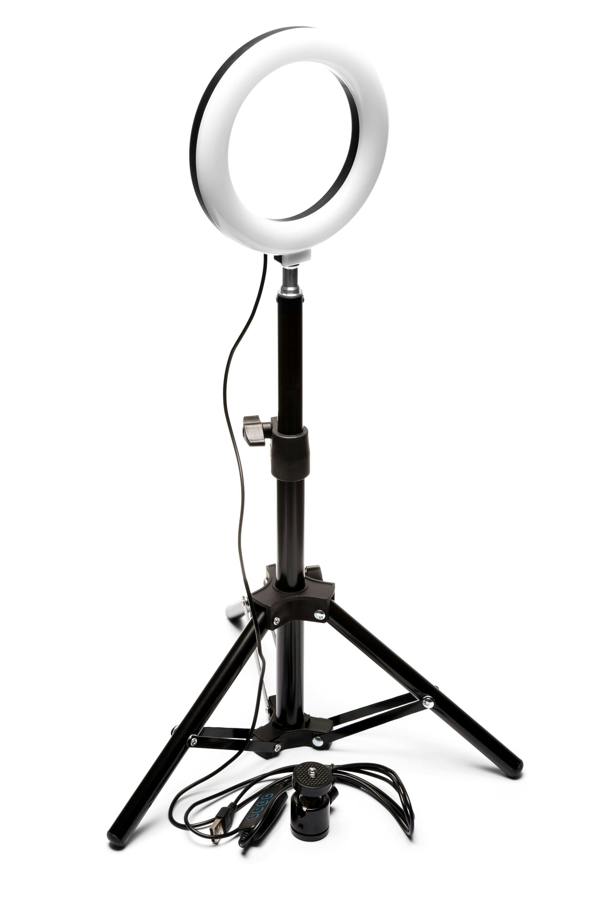 The Rio Makeup Perfector LED Ring Light, supported by a black tripod with a central smartphone holder and power cords at the base, is ideal for flawless makeup application in any lighting, shown here on a white background.