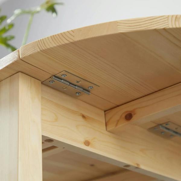 Close-up of natural wood drop-leaf hinge and metal support under the tabletop