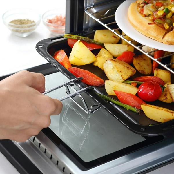 Hand sliding a food tray into a black countertop oven with rack and door