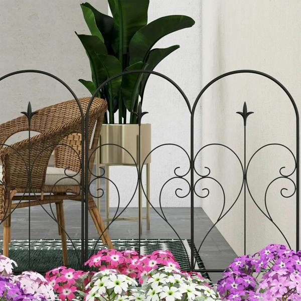 Black decorative metal fence panels with heart cutouts and scrollwork, arched top border