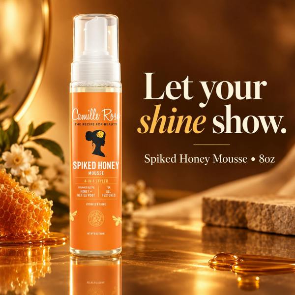 Camille Rose Spiked Honey Mousse bottle on a reflective gold surface with honeycomb, honey drops, and a stone, alongside promotional text reading 'Let your shine show. Spiked Honey Mousse • 8oz'.
