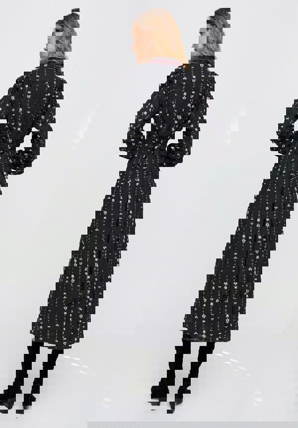 Woman wearing a black patterned dress on a white background