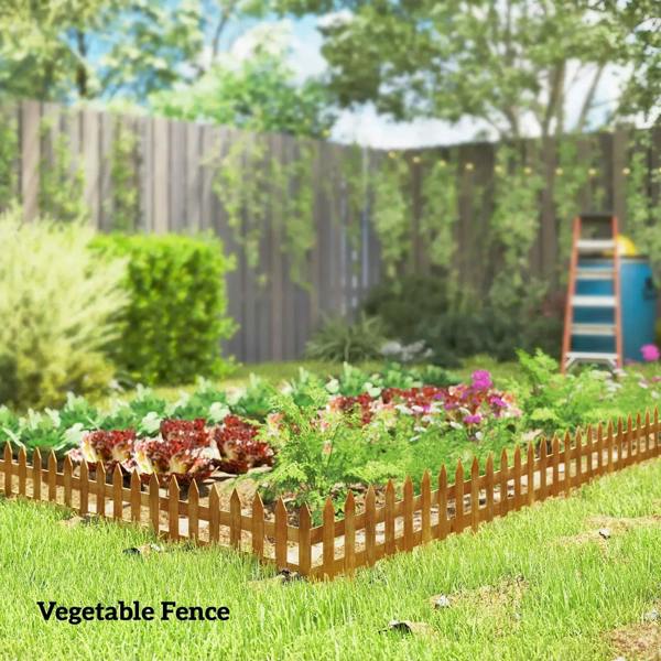 Brown wooden picket fence around vegetable garden bed, pointed stakes along lawn