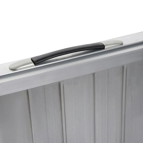 Silver folding ramp carry handle on aluminum panel with dark rubber grip