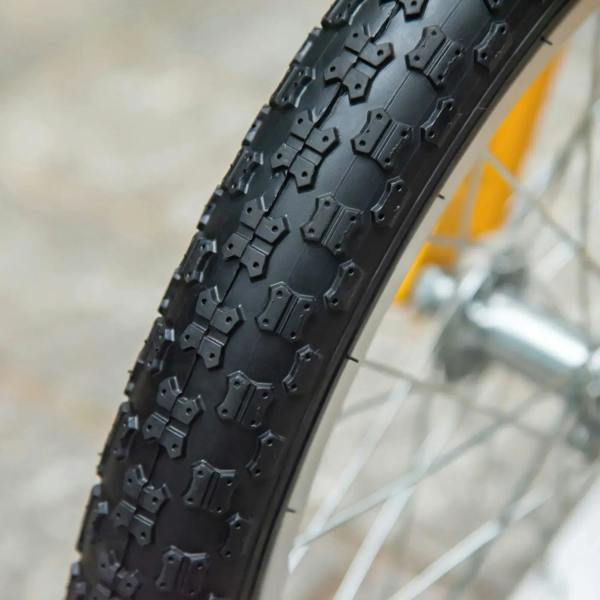 Close-up: black inflatable rubber wheel tire tread on orange kids scooter