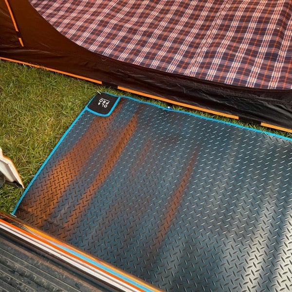 OLPRO Awning Tunnel Mat 1500mm x 800mm Black Rubber with Blue Edge Trim being used within a camper van awning in-between the awning tunnel and campervan.