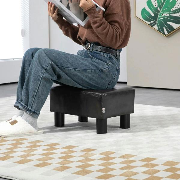Dark PU leather cube ottoman with square seat and four sturdy plastic legs.