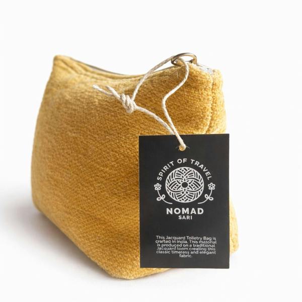 Mustard yellow jacquard toiletry bag close-up with hanging brand tag by zipper