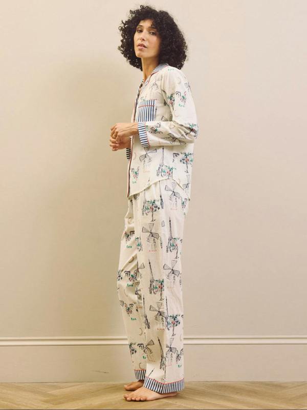 Woman wearing a navy and white Paris print pyjama set against a plain background