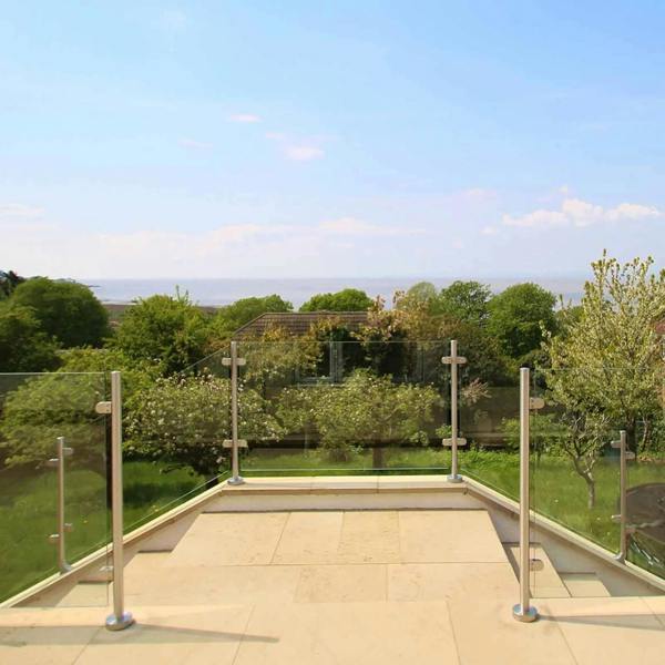 Stainless steel balustrade end post, 90cm high, showcasing a sleek design against a scenic outdoor view with greenery and sky