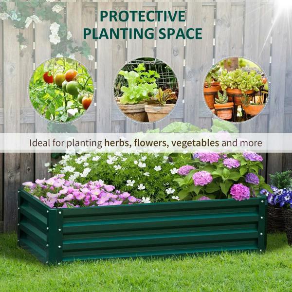 Green raised planter in a backyard with purple and white flowers along the bed