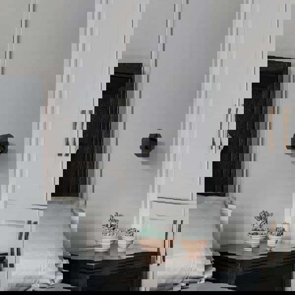 black bedside light for reading installed next to the bed on the wall in a modern bedroom