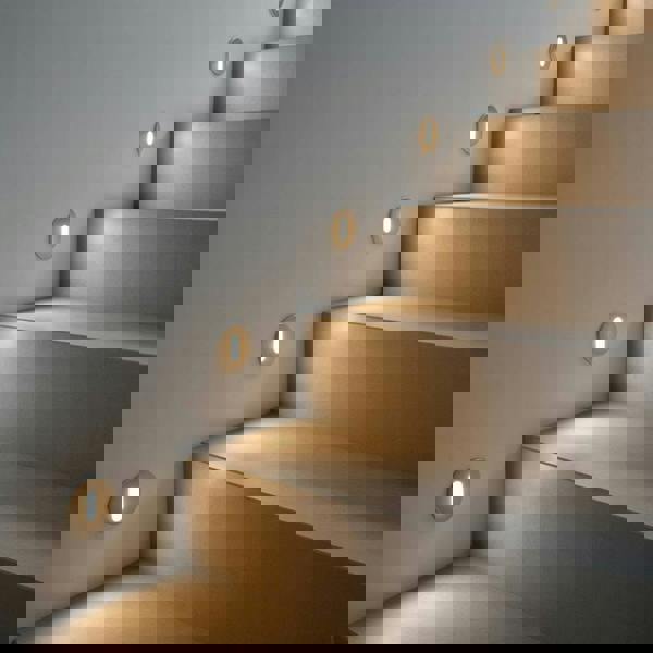 silver recessed step light mounted on the wall next to steps