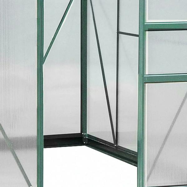 Interior view of dark green greenhouse with clear polycarbonate side panels and braces