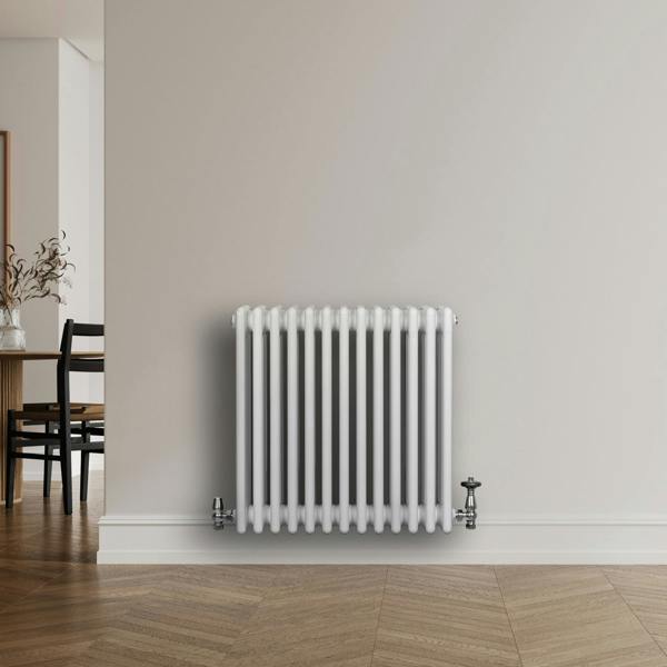 Traditional white 4 column radiator with chrome valves, featuring a sleek, smooth finish and a modern design, positioned against a neutral wall