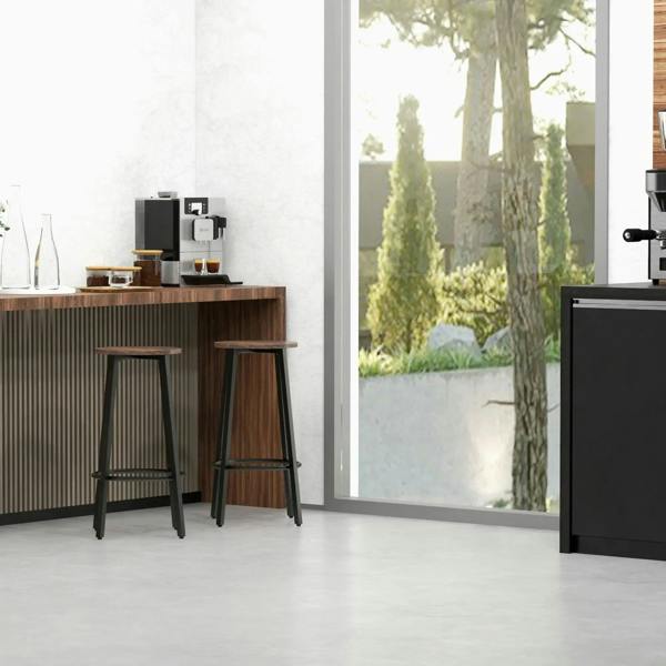 Industrial bar stools with round rustic brown seats, black steel legs, and circular footrest