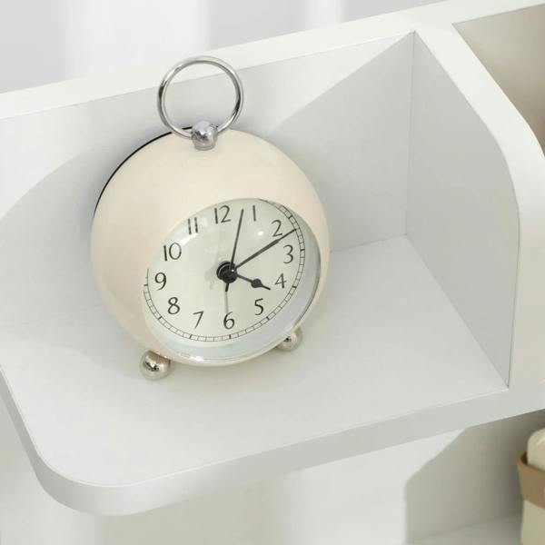 White open top shelf on a small bedside cabinet, with alarm clock displayed