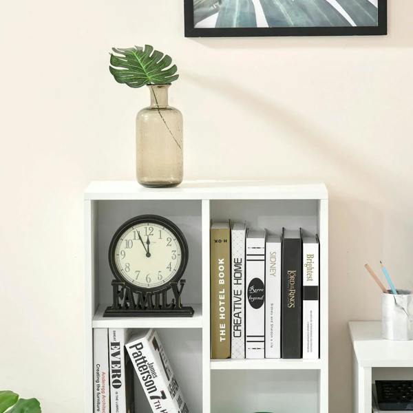White bookcase with open cubby shelves and top ledge, displaying books and small decor.