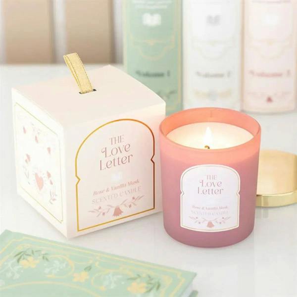 Pink scented candle jar with gold lid and front label