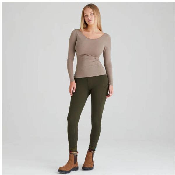 Women wearing the Ridgeline Infinity Leggings in deep forest with a pair of dealer boots
