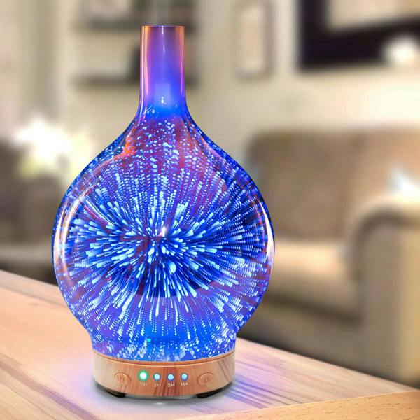 The Rio ELLA Aroma Diffuser, Humidifier and Night-Light features a glass design with a wooden base and emits vibrant blue and purple light patterns, adding a soothing touch to any softly lit living room.