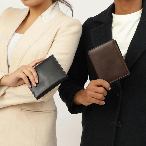 Two people holding leather passport wallets