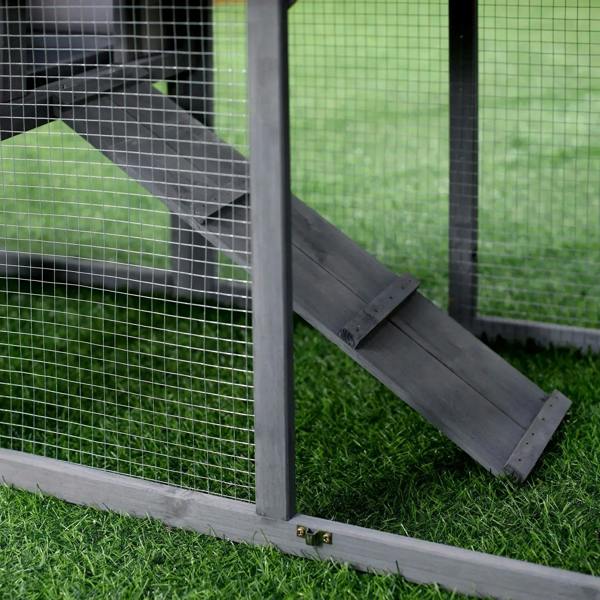 Grey rabbit hutch with wire mesh walls and angled entry ramp on the ground level
