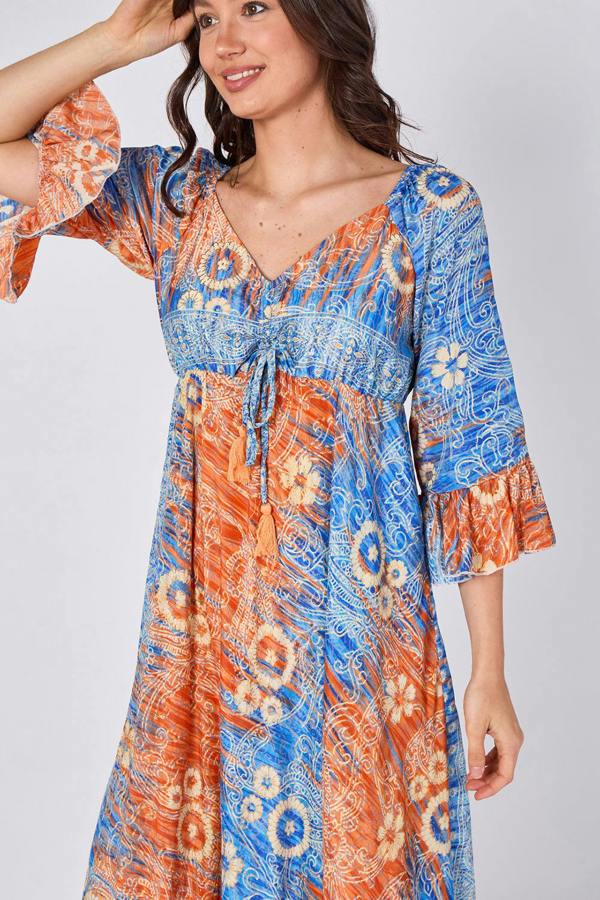 Woman wearing a blue and orange patterned dress on a white background