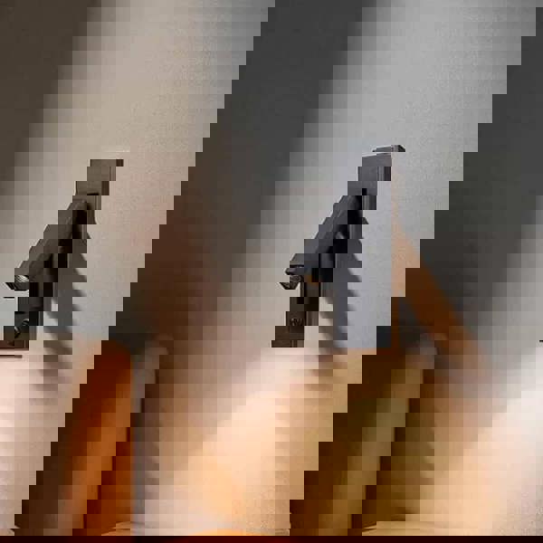 black recessed bedroom reading light mounted on the wall next to a bed 