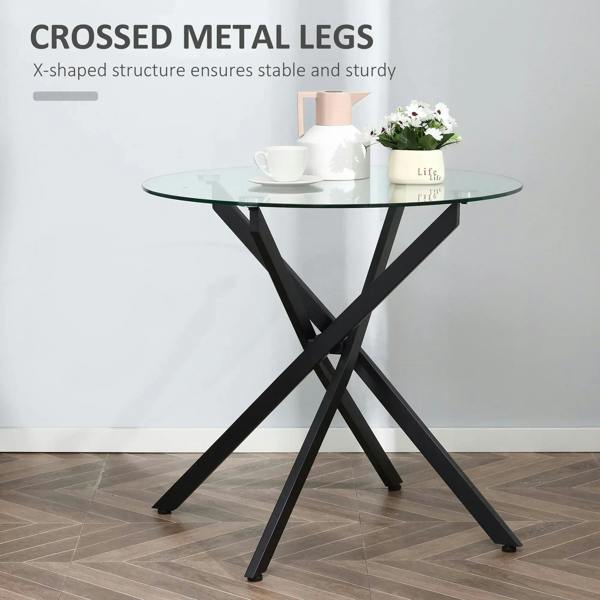 Round clear glass dining table with black X-shaped metal legs and sturdy base