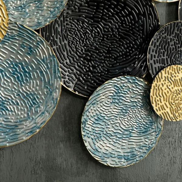 Close-up of textured blue and black metal discs with gold-accent circle