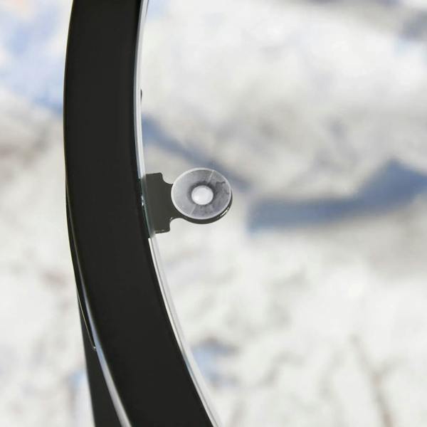 Close-up of black metal support and curved base ring detail beside glass tabletop.