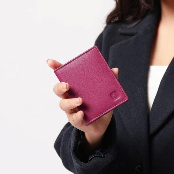 Person holding a Fuchsia wallet against a neutral background