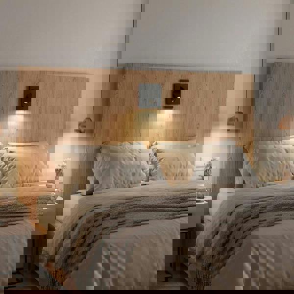 black recessed LED reading lamp for bed recessed into a wooden headboard over a bed in a modern bedroom