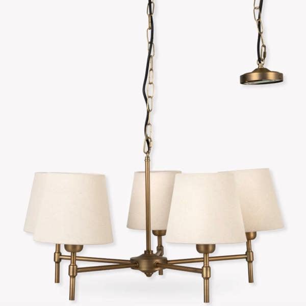 A studio product shot of the 5-light antique bronze steel chandelier with cream linen shades against a white background by Abode Home & Gifts.