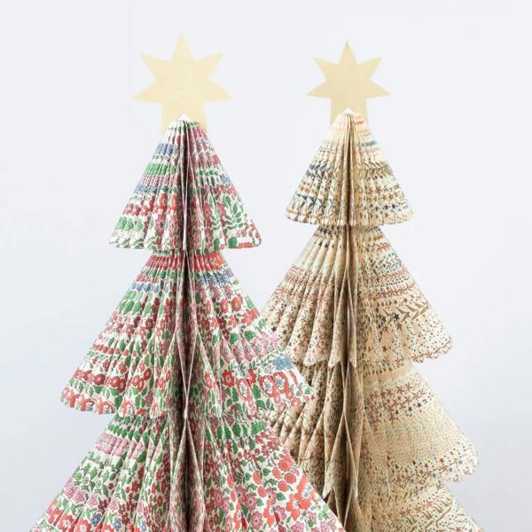 Close-up shot of two 3D paper honeycomb Christmas trees highlighting detailed Liberty floral and star patterns topped with gold stars.
