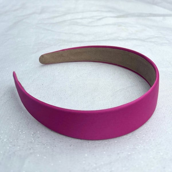 Hot pink hairband, smooth satin finish, bold vibrant shade, padded design, sleek minimalist style, statement fashion accessory
