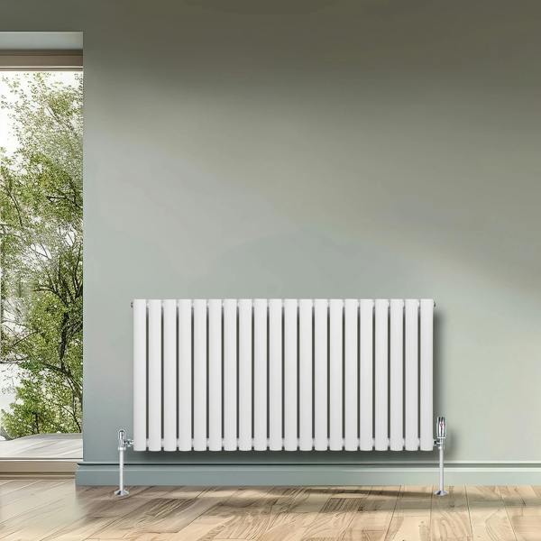 White oval single column radiator, 600 x 1200mm, featuring sleek vertical lines, mounted against a soft green wall in a bright room