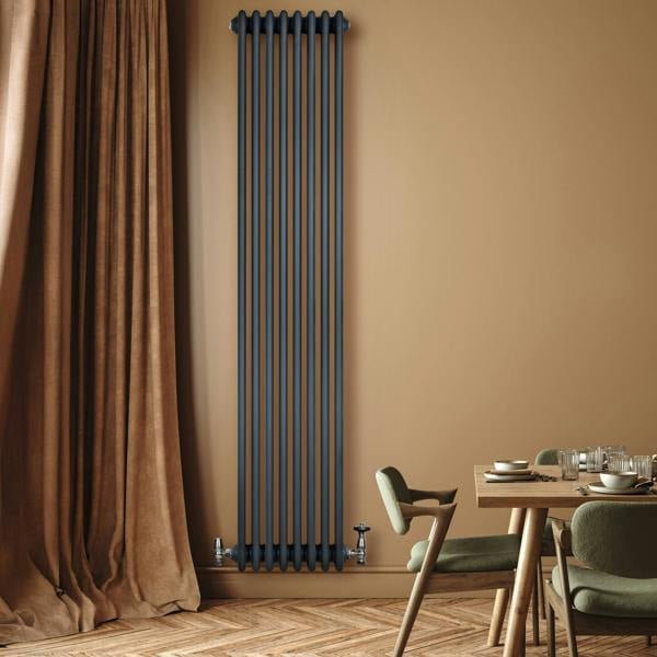 Traditional 4 column radiator in anthracite grey, featuring a sleek vertical design against a warm beige wall and wooden floor