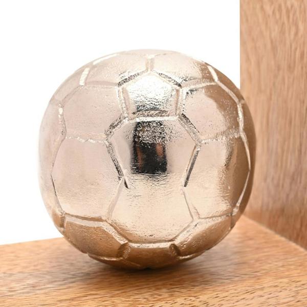 A close-up view of the detailed metallic silver football mounted onto the natural wood base of a decorative bookend.