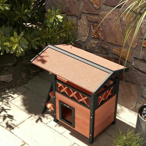 Outdoor cat house with roof and front door, dark legs and brown wood walls on patio