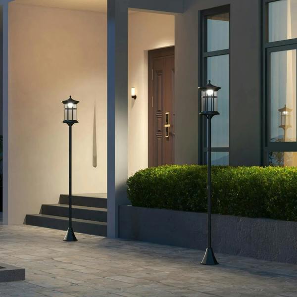 Black solar lamp posts standing by an entryway wall with lantern glass panels