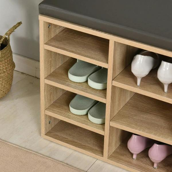 Open shoe cubbies in natural wood shoe rack with dark gray top cushion, partial view