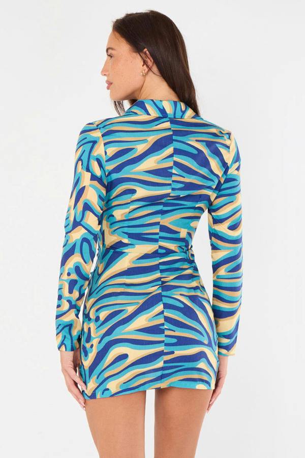Woman wearing a blue and yellow patterned dress on a white background