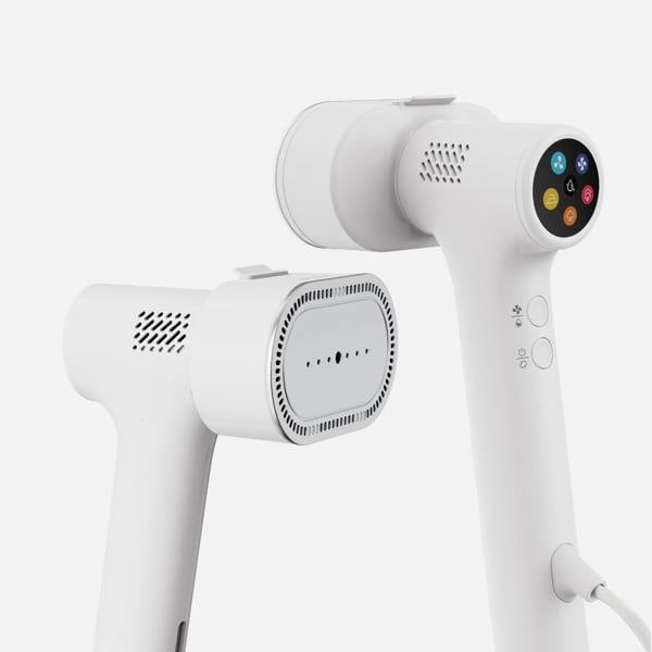 Two sleek white f20 Handheld Clothes Steamer Pro with Suction units from Fridja are shown. One displays a fabric selector screen with icons, while the other reveals the steam plate. Both steamers feature vents and buttons, embodying minimalist aesthetics characteristic of this advanced handheld garment care device.